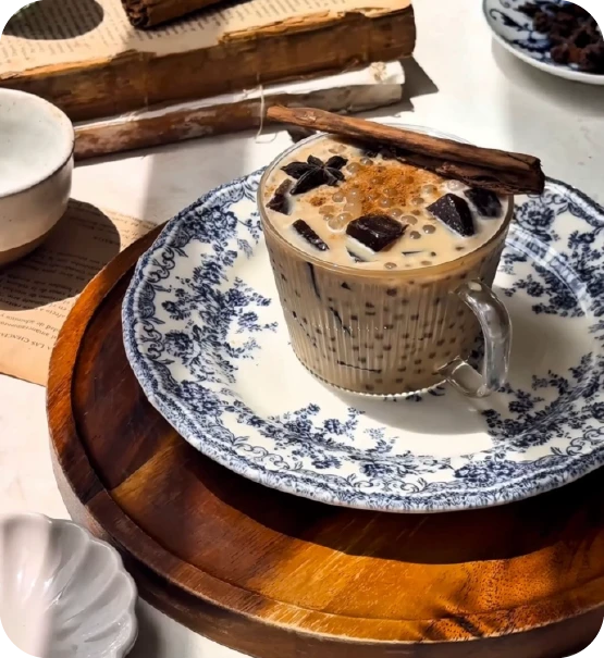 Un sago chai latte cremoso con coco y especias servido en una taza de vidrio